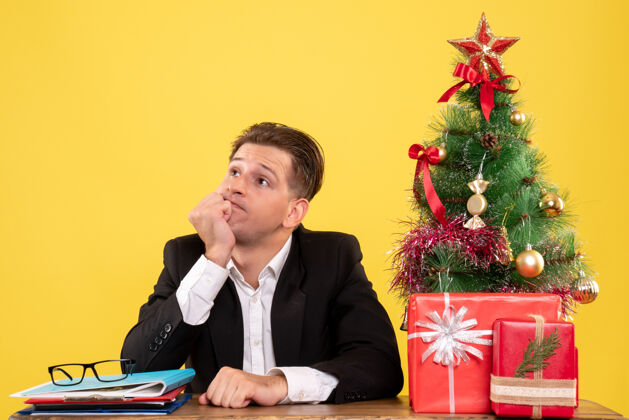 圣诞节正面图穿着西装的男工人坐在工作台后面 压力很大行政人员情绪商人
