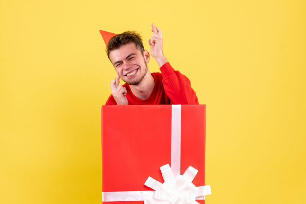 颜色正面图穿红衬衫的年轻男子坐在礼品盒内年轻衬衫坐着