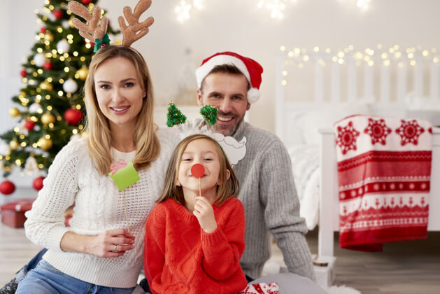 后代戴着圣诞面具微笑的一家人的画像家庭室内圣诞装饰女儿