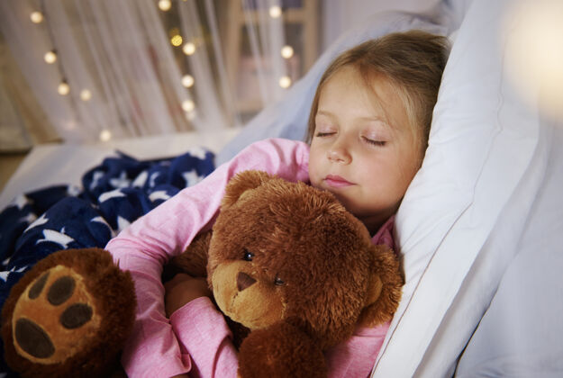 玩具和泰迪熊睡觉的小女孩仰卧睡觉部分
