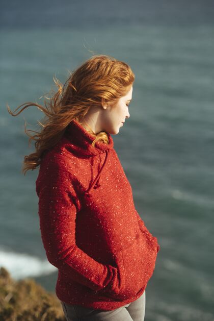 海岸一个女人站在海边的垂直镜头人魅力草