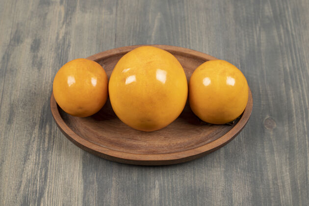新鲜美味多汁的柿子在木板上高品质的照片甜味成熟柿子