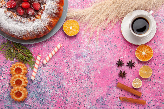 针顶视图美味草莓蛋糕糖粉蛋糕小饼干和一杯茶的粉红色办公桌蛋糕甜甜的糖饼干馅饼茶生的蛋糕