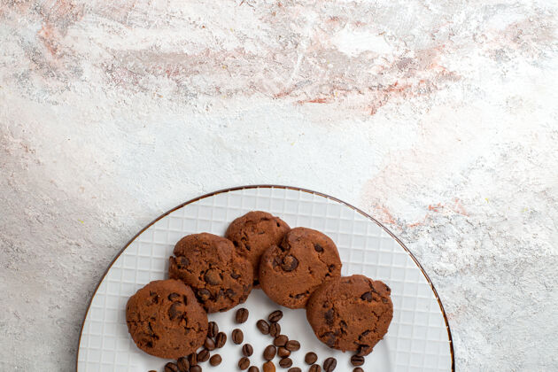 地板俯瞰美味的巧克力饼干与巧克力片对白色办公桌饼干糖甜烤蛋糕饼干地板封面饼干巧克力