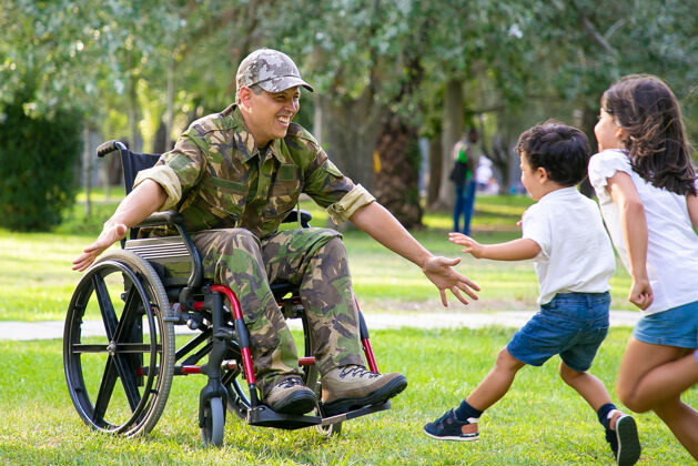 男孩开朗的孩子们见到军人爸爸 张开双臂向身着迷彩服的残疾人跑去拥抱老兵还是回家的概念高加索爸爸儿子