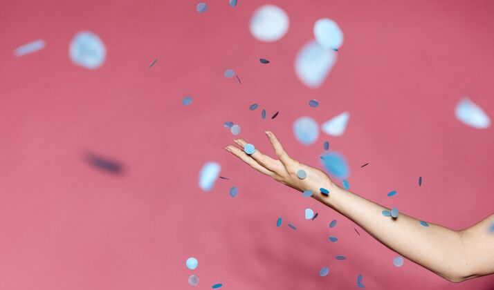 女人侧视图：手拿蓝色纸屑的女人五彩纸屑活动庆祝