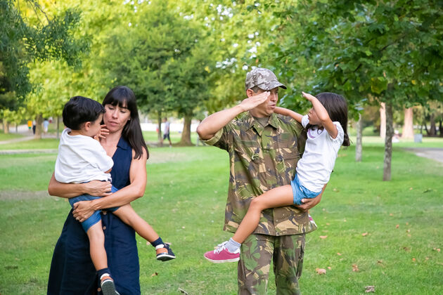 军人正军男子带着妻儿在公园散步 教女儿做军礼手势全长 后视家庭团聚还是军爸的概念教学孩子团结