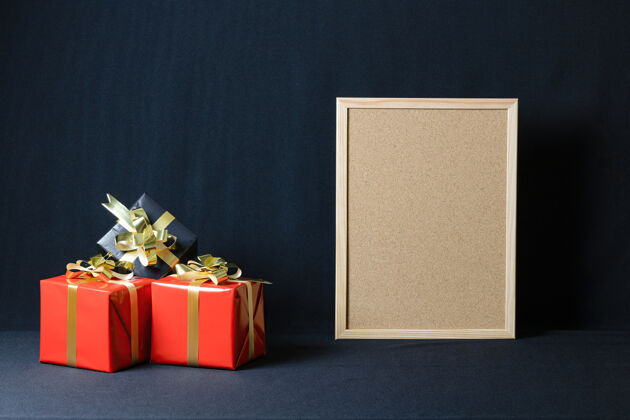 木板软木板和圣诞礼品盒与复制空间隔离在一个黑暗的背景包装空白传统