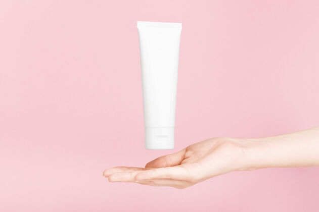 產品女性手拿著金冠奶油的flacon塑料flacon用于潤膚露 洗漱液美容帽子Visagiste