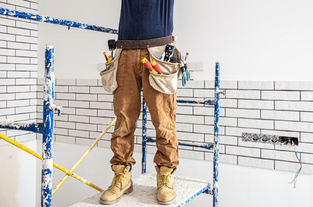 专业人员专业的工作服和工具背景上的维修现场电工工人建筑