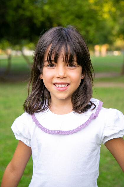 快乐快乐的小黑发女孩站在城市公园里孩子们在夏天享受户外休闲时光中镜头 垂直童年的概念享受中等活动