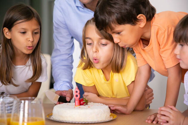 孩子可爱的孩子们吹灭蜡烛许愿金发碧眼的高加索女孩和朋友们一起庆祝生日 吃蛋糕快乐的孩子们一起玩童年 庆祝和节日的概念蜡烛可爱愿望