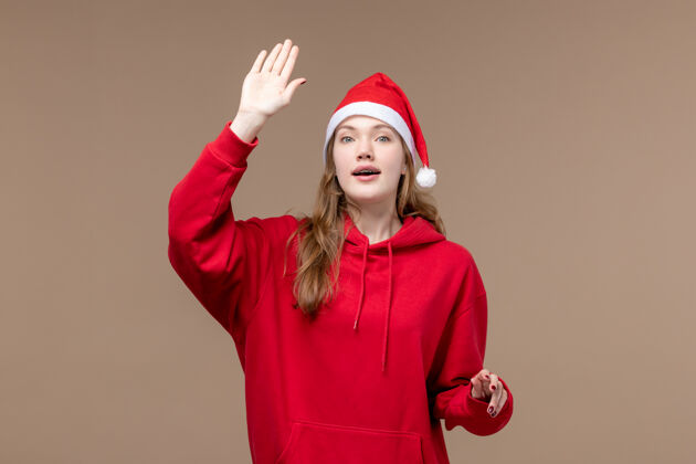 人正面图圣诞女孩在棕色背景上挥手庆祝圣诞节棕色挥手快乐