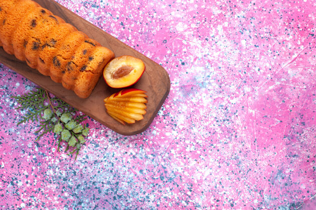 面包顶视图美味的蛋糕甜美可口 粉红色的桌子上有李子橙色食物李子