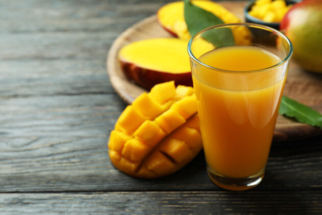 罐子木桌上放着成熟的芒果和果汁冰沙果汁有机