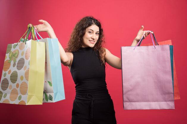 购物者快乐的女人 有很多红色背景的包衣服女孩买单