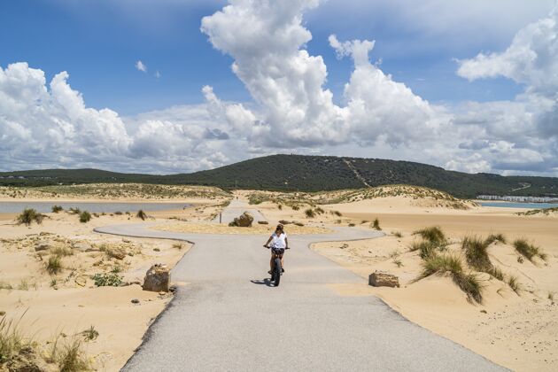 自然在西班牙的安达卢西亚 一个骑自行车穿过一条被海滩和大海包围的道路的人地中海乐趣旅游
