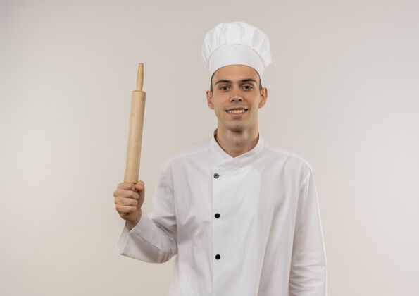 穿着面带微笑的年轻男厨师穿着厨师制服拿着擀面杖与复印空间别针男制服