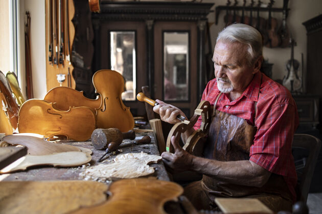 手工资深木匠在他的旧时尚工作室里雕刻木头木材刨花正品