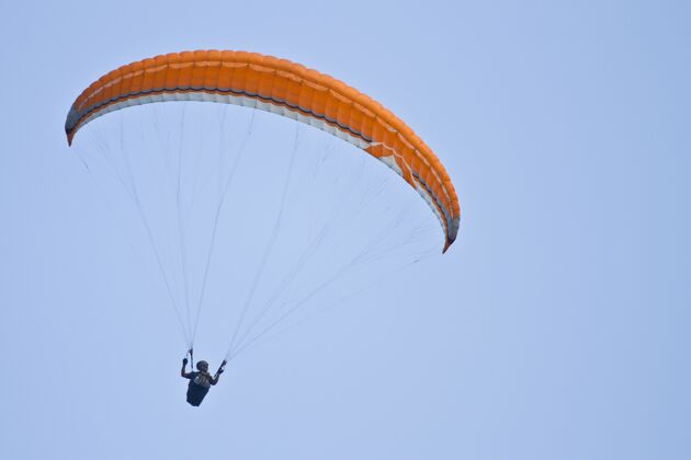 海滩人类在蓝天上滑翔伞的惊人镜头速度橙色冲浪