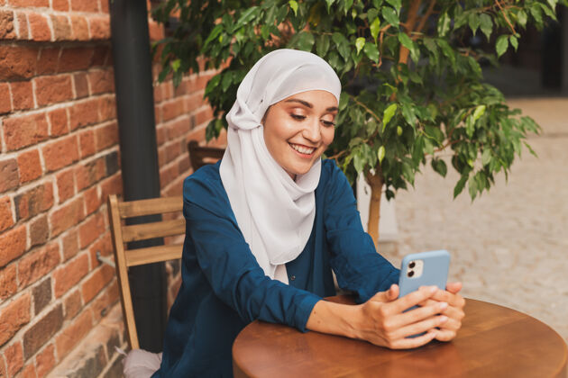 快乐的妇女在城市里用智能手机进行视频通话咖啡馆朋友电话