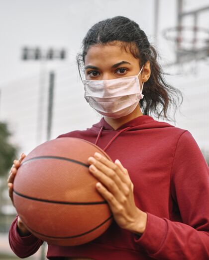 球戴着医用面罩拿着篮球的女人年轻运动装运动员