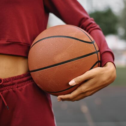 比赛女人拿着篮球在户外特写篮球球运动员