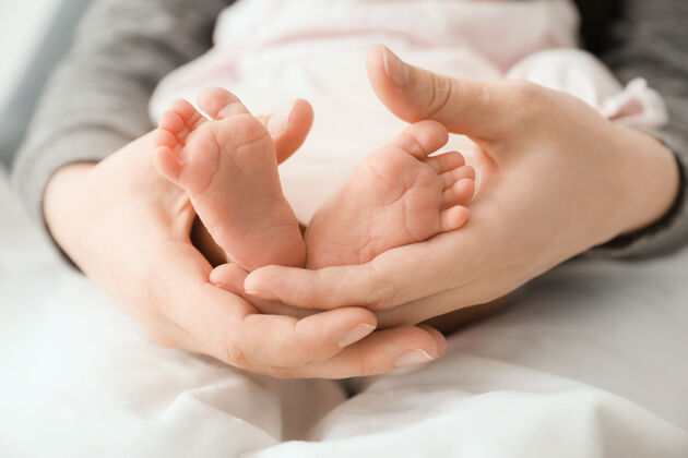 婴儿妈妈抱着小宝宝的小脚 特写女儿女性微小