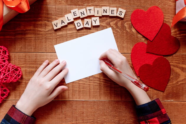 纸女孩的手写情书情人节手工制作的带有红色心形图案的贺卡2月14日是庆祝的日子从上面看信明信片女人