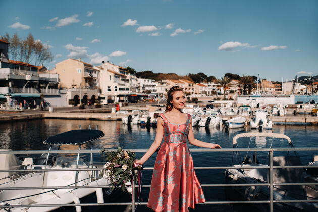 花在法国的海滩上 年轻的模特儿穿着漂亮的裙子 手里拿着一束鲜花水手游艇复古