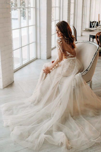 漂亮的礼服一个穿着婚纱的豪华新娘早上在她的室内早晨仪式新娘