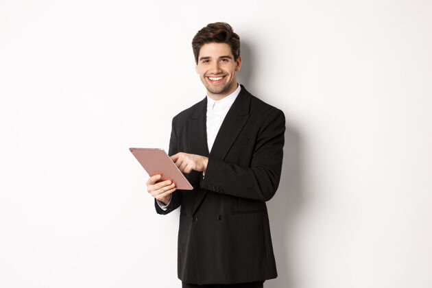 就业身着黑色西装 使用数码平板电脑 面带微笑的帅哥商人形象企业家智慧男士