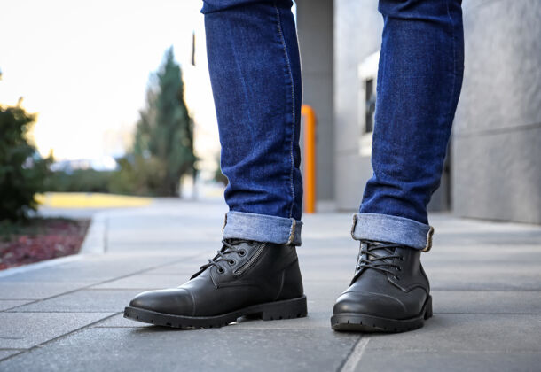 铺路城市街上穿着黑鞋子的时髦男人街道鞋子牛仔裤