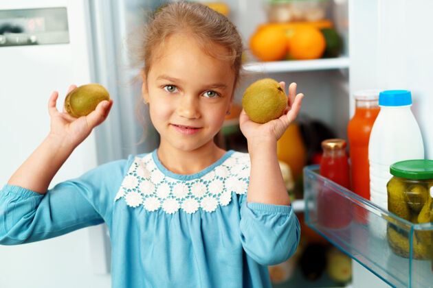 人站在冰箱前挑选食物的小女孩家庭脸白种人