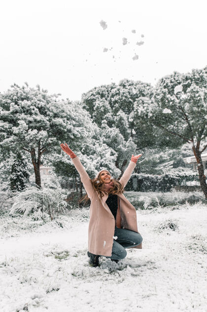 和谐时尚的年轻女子穿着暖和的衣服 在冬天扔雪 享受周末扔欢呼周末