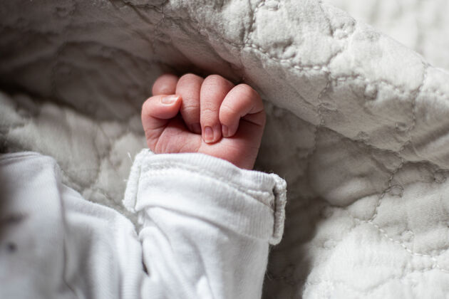 拳头婴儿床里新生婴儿的手手指手新生儿