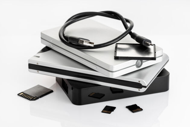 存储卡白色桌子上的一组外部硬盘和存储卡数据存储概念计算机数据库外部