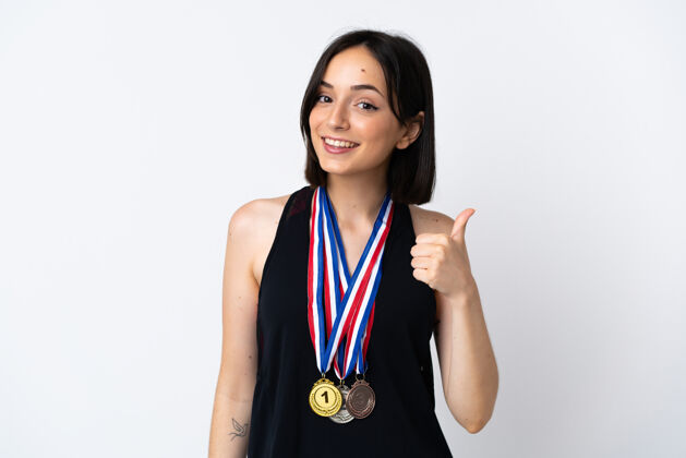 站年轻女子拿着奖牌隔离在白色背景上 竖起大拇指 因为发生了好事杉木获胜者青年
