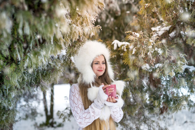 季节在冬季公园喝咖啡的年轻女子杯子户外咖啡