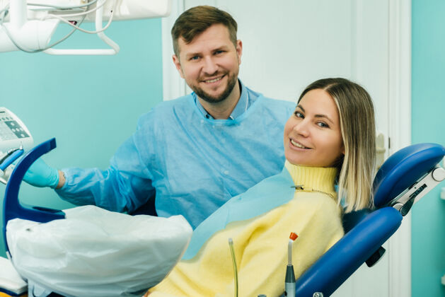 龋齿美丽的女病人坐在牙医的椅子上 用她的手向全班展示妇女美白访问