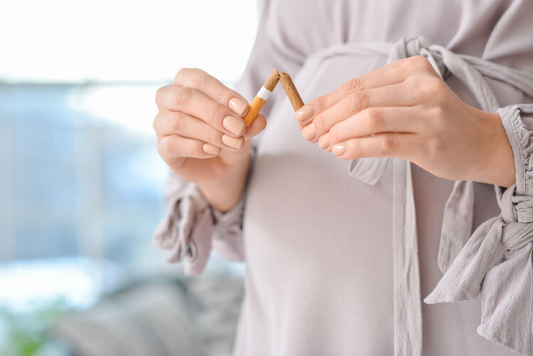 过滤年轻的孕妇拿着破烟 特写概念拒绝坏习惯怀孕破裂手
