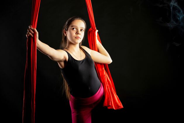 身体在体操表演开始前 一幅有目的的漂亮少女的肖像 黑色的空中红丝带平衡健身房风险