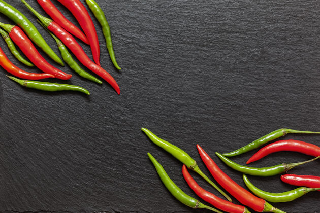 文字在石板板上放上新鲜的辛辣的红 绿辣椒 从上面的深色背景上放上各种五颜六色的辣椒和辣椒顶视图 复制空间膳食墨西哥配料