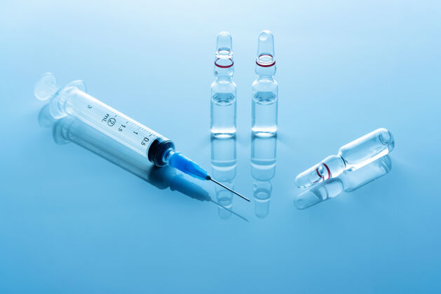 维生素蓝色表面上有疫苗和医用注射器的安瓿针刺设备集团