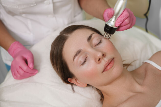 皮肤护理在美容院放松的女人的特写镜头 得到专业的面部程序皮肤科健康面部
