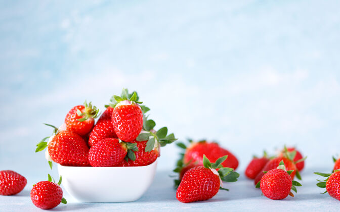 水果生的红色有机草莓在蓝色的背景上一串健康树叶抗氧化剂