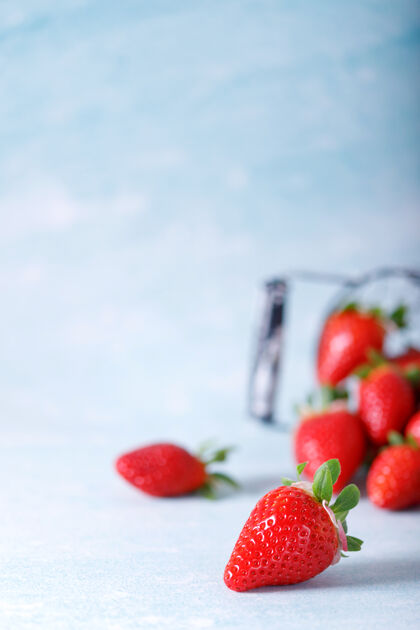 整体生的红色有机草莓在蓝色的背景上一串提神明亮草莓