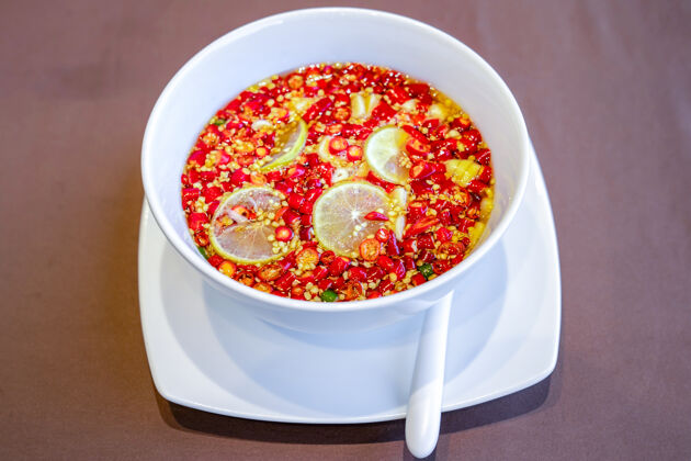 菜特写泰国传统酱汁辣椒白碗柠檬酸橙蒜鱼露健康调味料酸橙