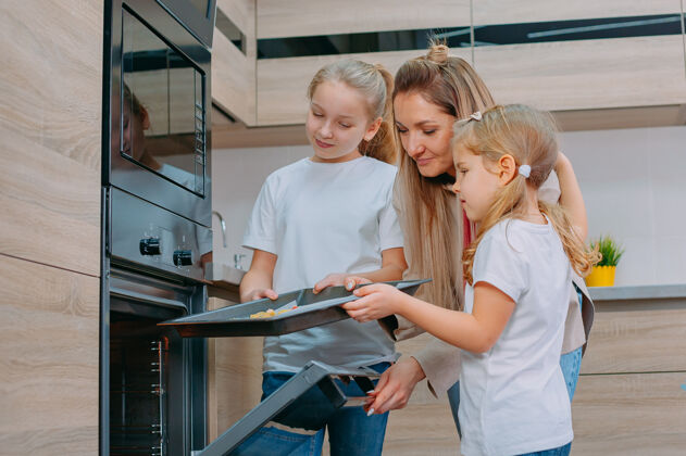 债券妈妈教她的女儿们在厨房做饭孩子女人菜肴