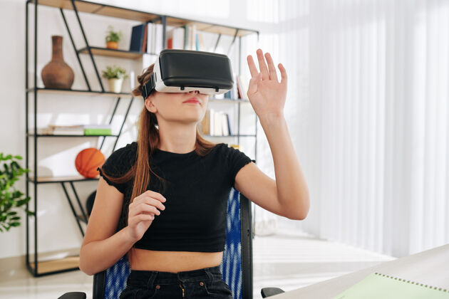 家庭室内十几岁的女孩周末在家里玩虚拟现实眼镜游戏高加索虚拟现实微笑